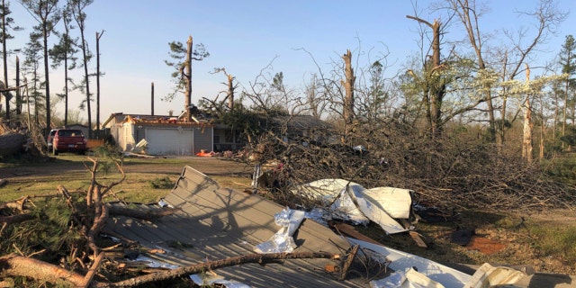Debris covers the ground around a home that was damaged from severe weather in Wynne, Arkansas, on Saturday, April 1, 2023.