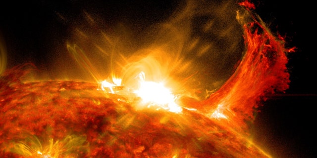 NASA's Solar Dynamics Observatory captured this image of a solar flare on Oct. 2, 2014. The solar flare is the bright flash of light at top. A burst of solar material erupting out into space can be seen just to the right of it.