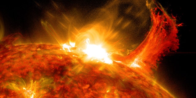 NASA's Solar Dynamics Observatory captured this image of a solar flare on Oct. 2, 2014. The solar flare is the bright flash of light at top. A burst of solar material erupting out into space can be seen just to the right of it.