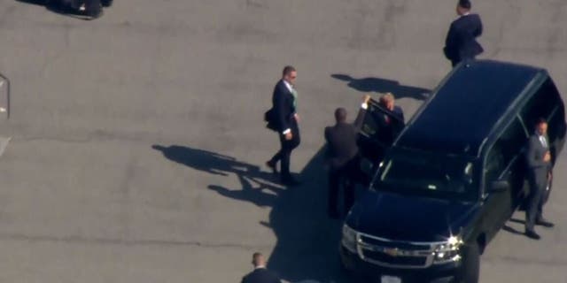 Trump enters an SUV in a motorcade on the LaGuardia International Airport tarmac in New York on Monday.