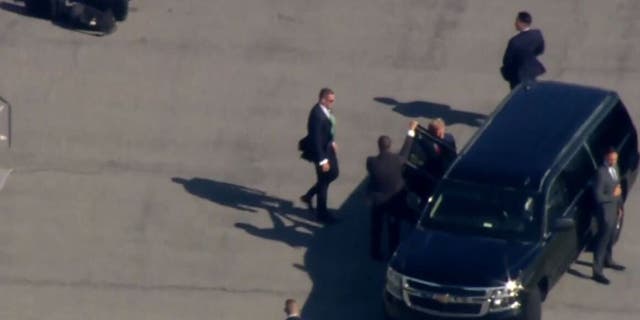 Trump enters an SUV in a motorcade on the LaGuardia International Airport tarmac in New York on Monday.