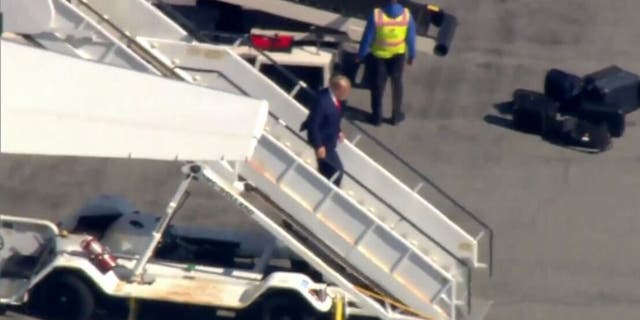 Trump exits his plane in New York to surrender in hush money payment case.
