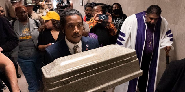 Rep. Justin Jones, D-Nashville, carries a casket through the halls of the state Capitol with Rev. William J. Barber, right, on April 17, 2023, in Nashville, Tennessee.