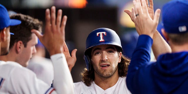 Josh Smith #47 of the Texas Rangers celebrates with teammates in the dugout during a game against the Philadelphia Phillies on Opening Day at Globe Life Field on March 30, 2023 in Arlington, Texas.