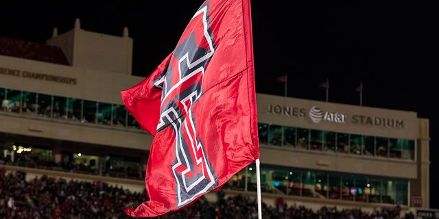 Texas Tech cheerleaders carry flags across the end zone during the Kansas Jayhawks game at Jones AT&amp;T Stadium on Nov. 12, 2022, in Lubbock, Texas.
