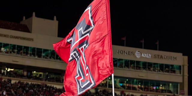 Texas Tech cheerleaders carry flags across the end zone during the Kansas Jayhawks game at Jones AT&T Stadium on Nov. 12, 2022, in Lubbock, Texas.