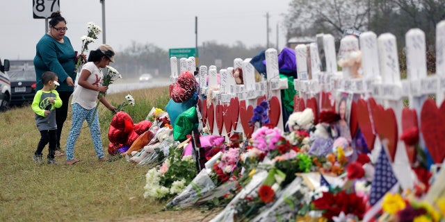 Christina Osborn and her children Alexander Osborn and Bella Araiza visit a makeshift memorial for the victims of the shooting at Sutherland Springs Baptist Church on Nov. 12, 2017, in Sutherland Springs, Texas. 