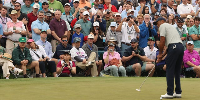 Patrons look on as Tiger Woods of the United States putts on the ninth green during a practice round prior to the 2023 Masters Tournament at Augusta National Golf Club on April 04, 2023 in Augusta, Georgia.