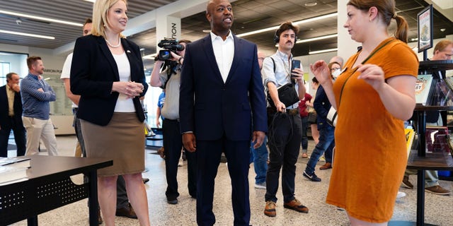 Sen. Tim Scott, R-S.C., center, tours the Marion Public Library with Rep. Ashley Hinson, R-Iowa, left, Wednesday, April 12, 2023, in Marion, Iowa. Scott on Wednesday launched an exploratory committee for a 2024 GOP presidential bid, a step that comes just shy of making his campaign official. (AP Photo/Charlie Neibergall)