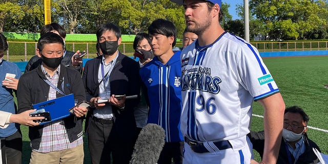 Yokohama BayStars Trevor Bauer está rodeado de reporteros en Yokosuka, Japón, el domingo 16 de abril de 2023.