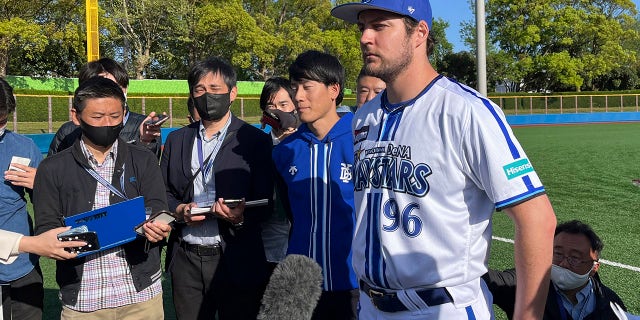 Yokohama BayStars Trevor Bauer está rodeado de reporteros en Yokosuka, Japón, el domingo 16 de abril de 2023.