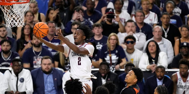 Connecticut guard Tristen Newton (2) drives to the basket over Miami defenders during the second half of a Final Four college basketball game in the NCAA Tournament on Saturday, April 1, 2023, in Houston.