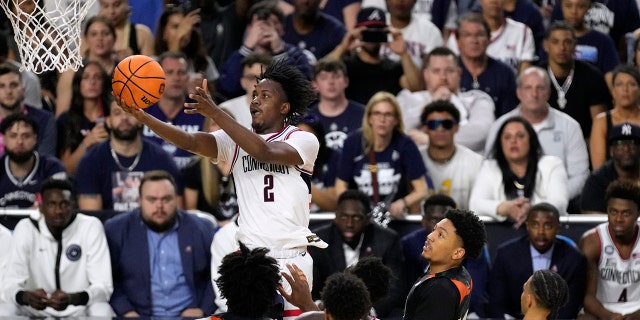 Connecticut guard Tristen Newton (2) drives to the basket over Miami defenders during the second half of a Final Four college basketball game in the NCAA Tournament on Saturday, April 1, 2023, in Houston.