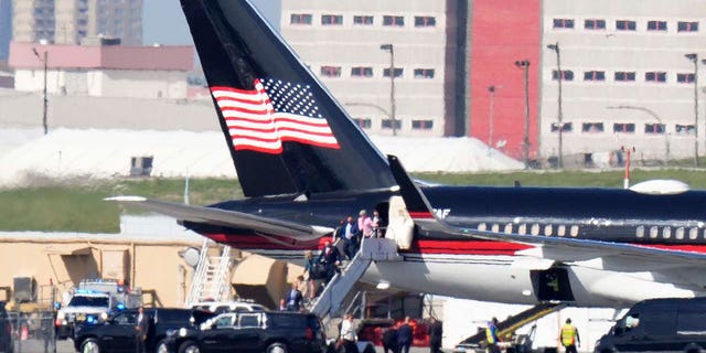 Former President Donald Trump's aides and legal team exit his plane in New York City on Monday.