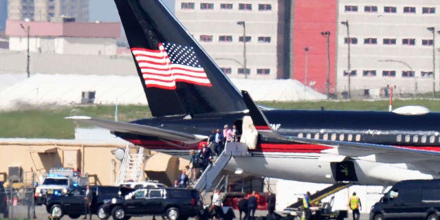 Former President Donald Trump's aides and legal team exit his plane in New York City on Monday.