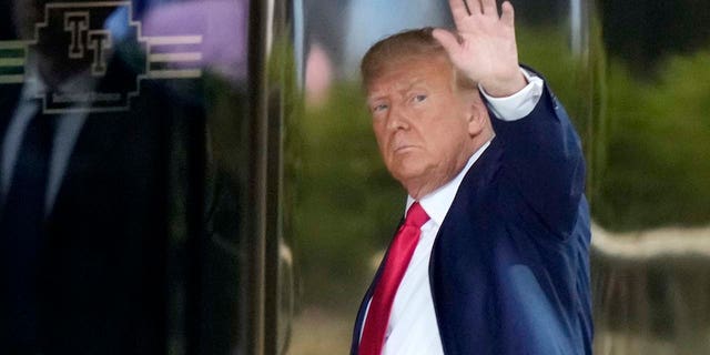 Trump is photographed waving to crowds before entering Trump Tower on Monday.