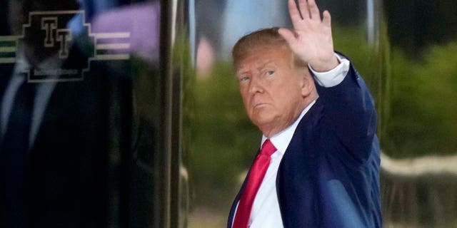 Trump is photographed waving to crowds before entering Trump Tower on Monday.
