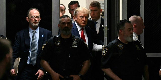 Trump makes his way to a courtroom to be arraigned on Tuesday.