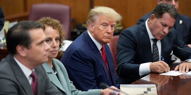 Former President Donald Trump sits with his defense team in a Manhattan court on April 4, 2023, in New York City.