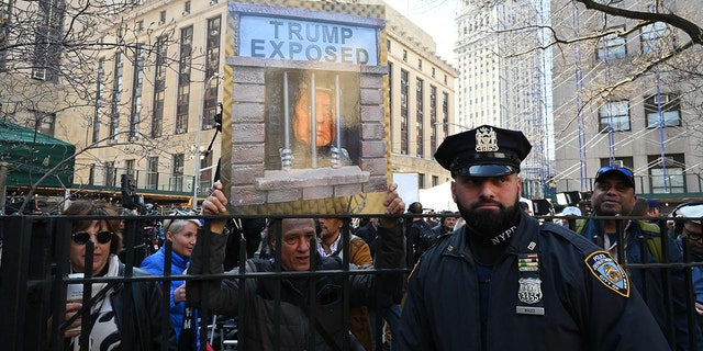Opponents of former US president Donald Trump protest outside the Manhattan District Attorney's office in New York on April 4, 2023. - Donald Trump will make an unprecedented appearance before a New York judge on April 4, 2023 to answer criminal charges that threaten to throw the 2024 White House race into turmoil. 