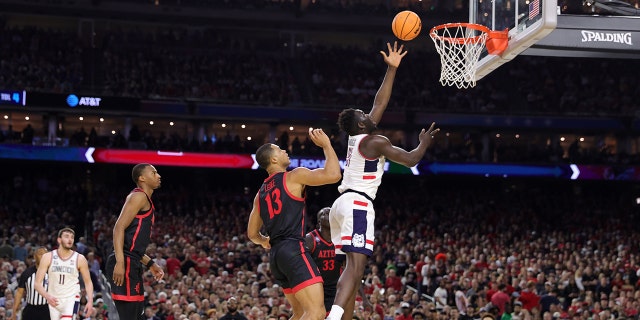 Adama Sanogo #21 of the Connecticut Huskies shoots the ball against Jaedon LeDee #13 of the San Diego State Aztecs during the first half during the NCAA Men's Basketball Tournament National Championship game at NRG Stadium on April 03, 2023 in Houston, Texas.