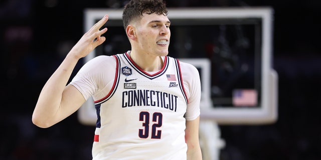 Donovan Clingan #32 of the Connecticut Huskies reacts after teammate Joey Calcaterra #3 (not pictured) makes a three-point basket during the second half against the San Diego State Aztecs during the NCAA Men's Basketball Tournament National Championship game at NRG Stadium on April 03, 2023 in Houston, Texas.