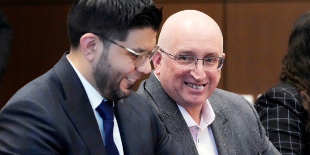 Robert E. Crimo Jr., right, father of Robert Crimo III, smiles as he sits with his attorney George Gomez, left, during an appearance before Judge George D. Strickland at the Lake County, Ill., Courthouse, Tuesday, April 4, 2023, in Waukegan, Ill.