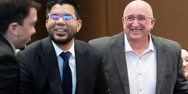 Robert E. Crimo Jr., right, father of Robert Crimo III, smiles as he sits with his attorney George Gomez, left, during an appearance before Judge George D. Strickland at the Lake County, Ill., Courthouse, Tuesday, April 4, 2023, in Waukegan, Ill.