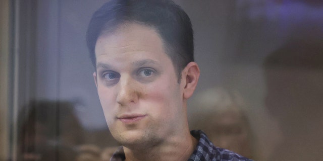 El reportero del Wall Street Journal, Ivan Gershkovich, quien fue arrestado en marzo durante un viaje de reportaje y acusado de espionaje, se para detrás de una pared de vidrio del recinto de un acusado antes de una audiencia judicial sobre una apelación contra su arresto, en Moscú, Rusia, el 18 de abril. , 2023.