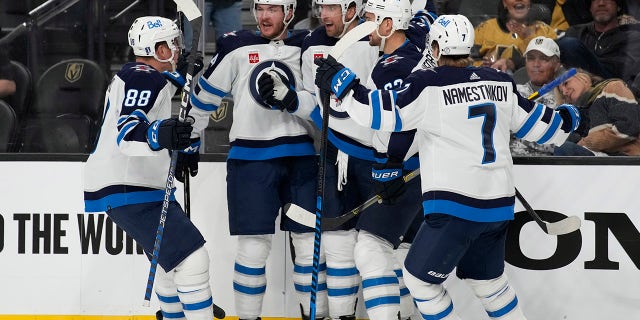 Winnipeg Jets celebrate after right wing Blake Wheeler, center, scored against the Vegas Golden Knights during the third period of Game 1 of an NHL hockey Stanley Cup first-round playoff series Tuesday, April 18, 2023, in Las Vegas.