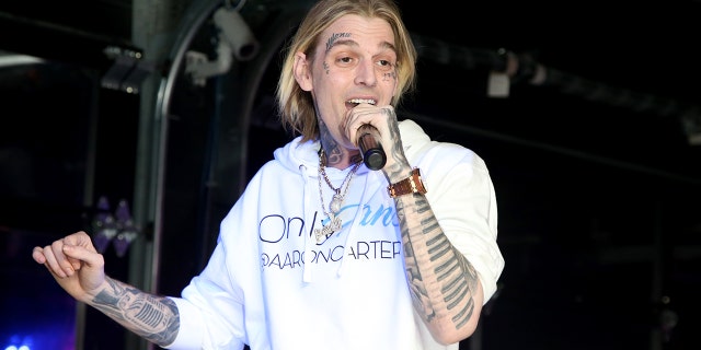 Aaron Carter wears white Only Fans sweatshirt during concert