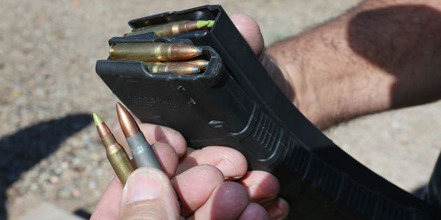 A man holds a high-capacity ammunition magazine on Oct. 25, 2018, in Cedar City, Utah. A Seattle, Washington, gun shop owner is facing penalties for disregarding a state law banning sales of high-capacity ammunition magazines.Â