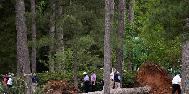 Course officials look over fallen trees on the 17th hole during the second round of the 2023 Masters Tournament at Augusta National Golf Club in Augusta, Georgia, on Friday.