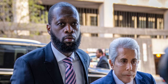Hip-hop group Fugees member Prakazrel "Pras" Michel, left, accompanied by a defense lawyer, arrives at a federal court for his trial in an alleged campaign finance conspiracy on March 30, 2023, in Washington. 