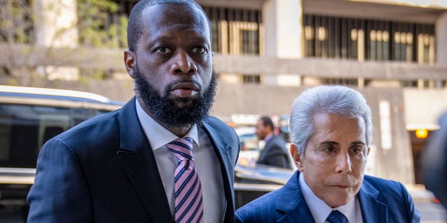 Hip-hop group Fugees member Prakazrel "Pras" Michel, left, accompanied by a defense lawyer, arrives at a federal court for his trial in an alleged campaign finance conspiracy on March 30, 2023, in Washington.