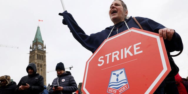 Huelga de trabajadores del gobierno canadiense, citan licencia pagada para pueblos indígenas e iniciativas contra el racismo entre las demandas 4 Un manifestante con un cartel de huelga fuera del Parlamento canadiense