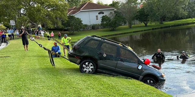dive teams recovering car from pond