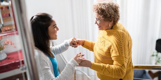 A nurse helping an older woman