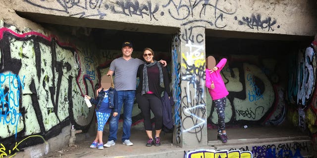 Bob Lee and family standing in concrete space covered in graffiti