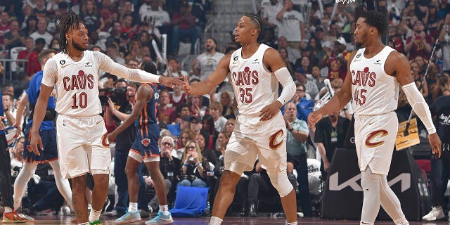 Darius Garland #10 high fives Isaac Okoro #35 of the Cleveland Cavaliers during the 2023 Round 1 Game 1 NBA Playoffs against the New York Knicks on April 15, 2023 at Rocket Mortgage FieldHouse in Cleveland, Ohio.