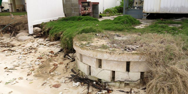A partially exposed cinderblock cesspool pit with a lid sits on a badly eroding shoreline in Punaluu, Hawaii. Tens of thousands of cesspools released 50 million gallons of raw sewage into the state's pristine waters every day.