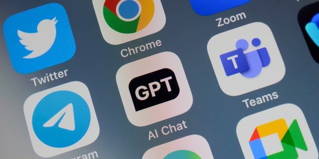 Aplikasi ChatGPT ditampilkan di layar iPhone dengan label "Obrolan AI" dikelilingi oleh aplikasi komunikasi dan akses web lainnya