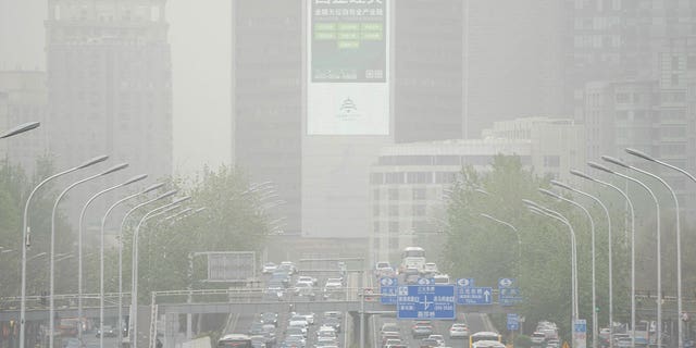 Cars drive along an expressway during a sandstorm in Beijing, on April 13, 2023. Many areas in northern China were blanketed with floating sand and dust on Thursday.