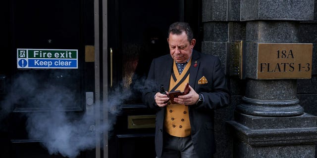 A man smokes an e-cigarette in a fire escape doorway in London, Britain, on Nov. 13, 2022. Residents in Britain will be encouraged to swap cigarettes for vapes in the world’s first "swap to stop" plan.