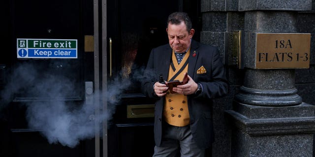 A man smokes an e-cigarette in a fire escape doorway in London, Britain, on Nov. 13, 2022. Residents in Britain will be encouraged to swap cigarettes for vapes in the world’s first "swap to stop" plan.