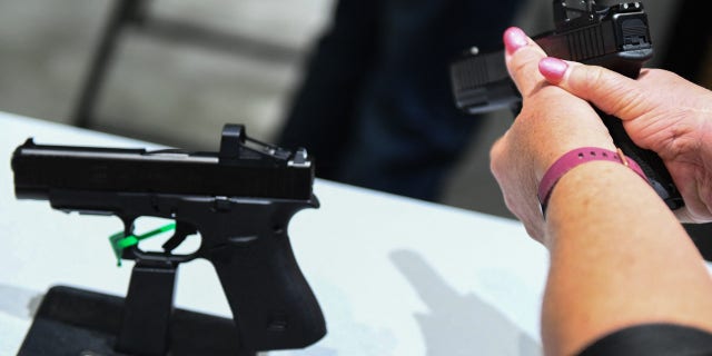 An attendee holds a Glock Ges.m.b.H. GLOCK 19 Gen5 9mm pistol during the National Rifle Association (NRA) Annual Meeting at the George R. Brown Convention Center, in Houston, Texas on May 28, 2022.