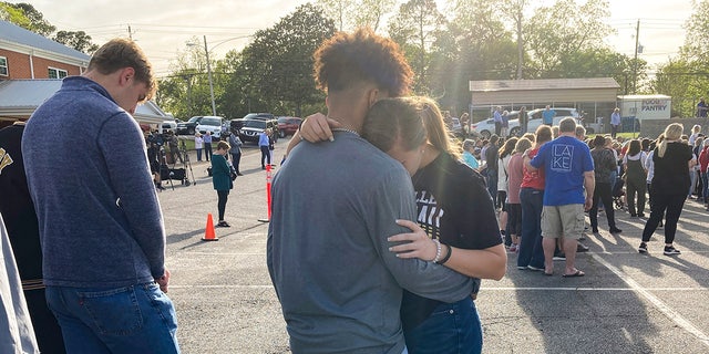 Two teens embrace at a prayer vigil on Sunday outside First Baptist Church in Dadeville, Alabama, following the Saturday night shooting.