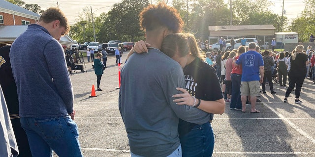 Two teens embrace at a prayer vigil on Sunday outside First Baptist Church in Dadeville, Alabama, following the Saturday night shooting.
