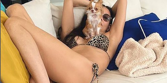 Demi More posing with her dog in a bikini