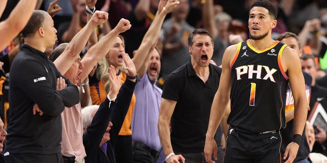 Phoenix Suns takımından 1 numaralı Devin Booker, 18 Nisan 2023'te Phoenix, Arizona'da Footprint Center'da Batı Konferansı Birinci Tur Playofflarının İkinci Maçının ilk yarısında LA Clippers'a üç sayılık atış yaptıktan sonra tepki veriyor.